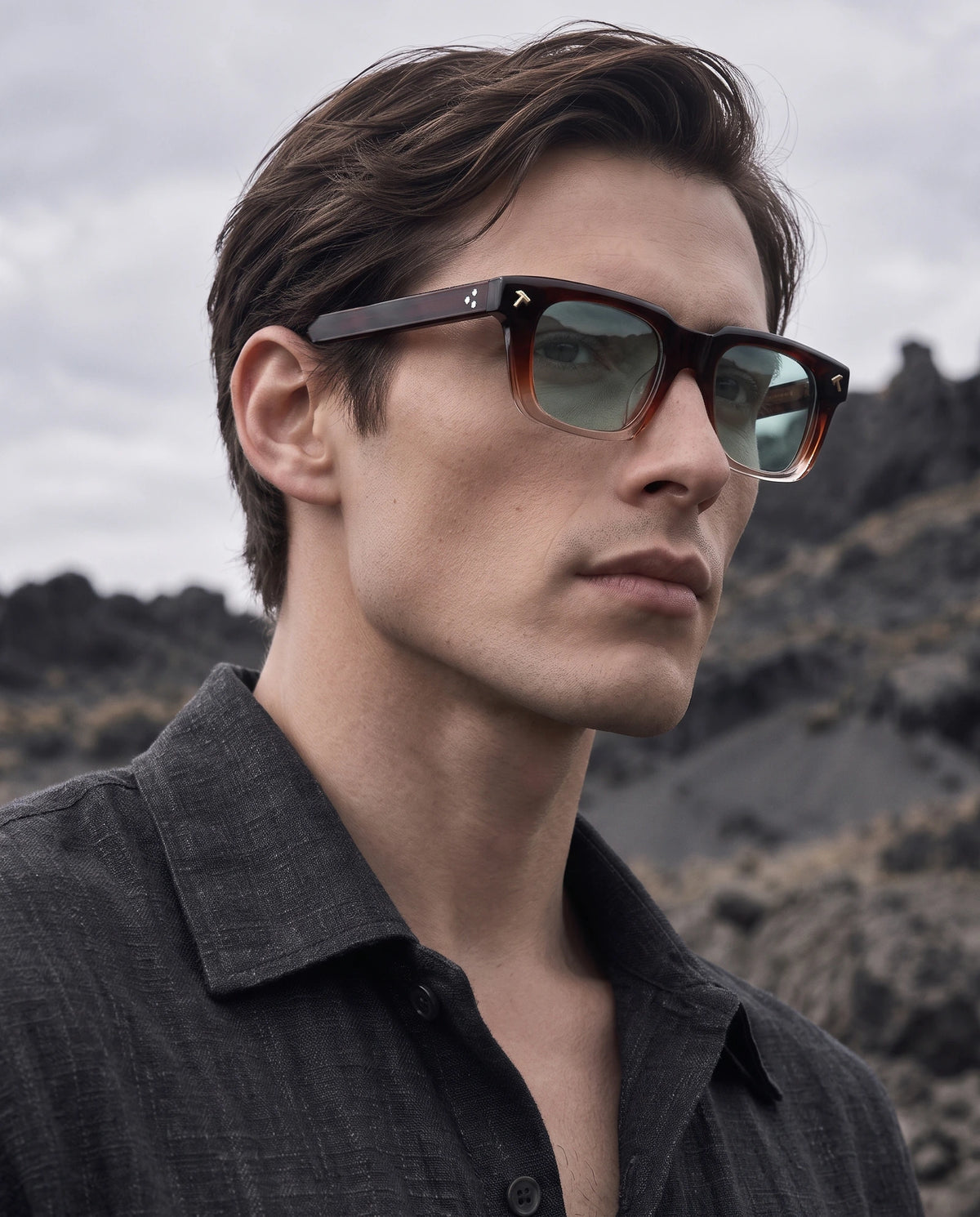 quen gradient red acetate sunglasses with green lenses worn by a male model in a mountain landscape