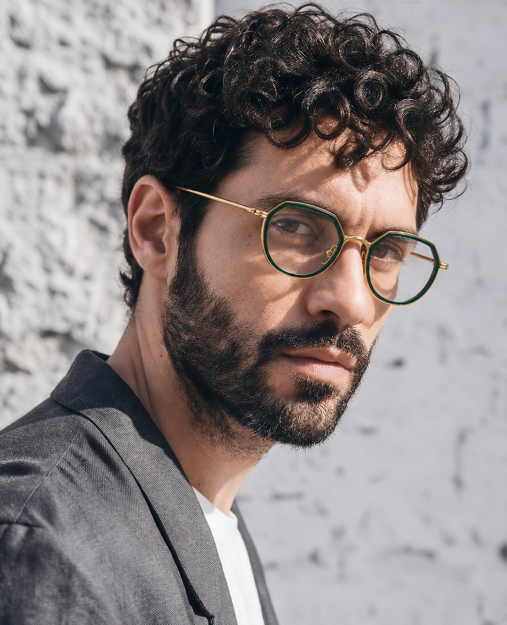 yt-01 green and gold geometric optical frame worn by a male model against a grey wall